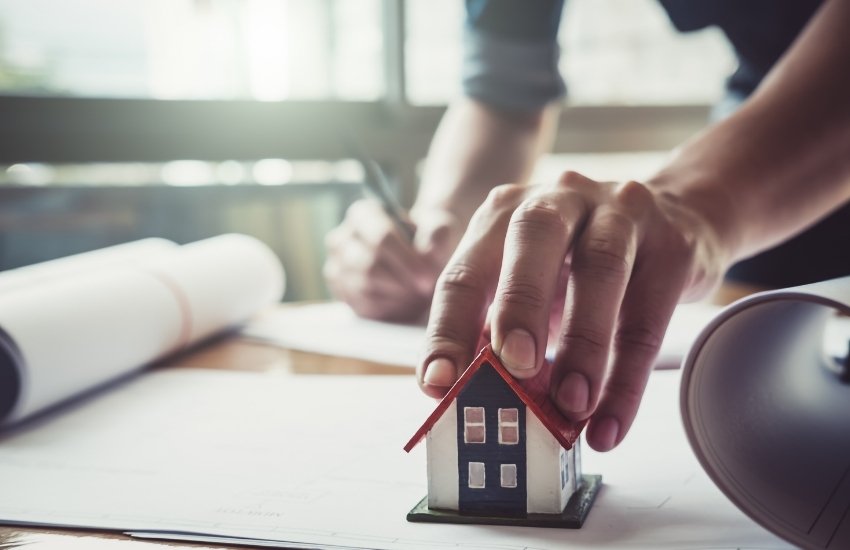 prashita assocaites a house in person hand and its on table for planning and research